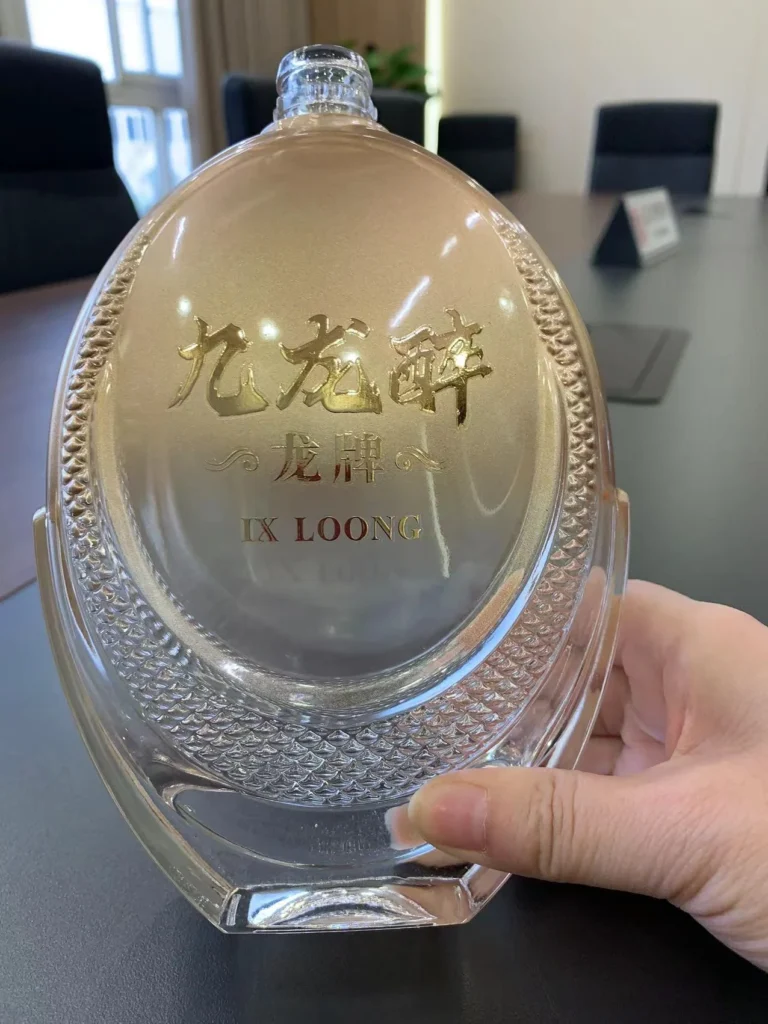 Custom-made liquor bottle featuring sophisticated gold gradient spray coating and private label embossed gold decal.