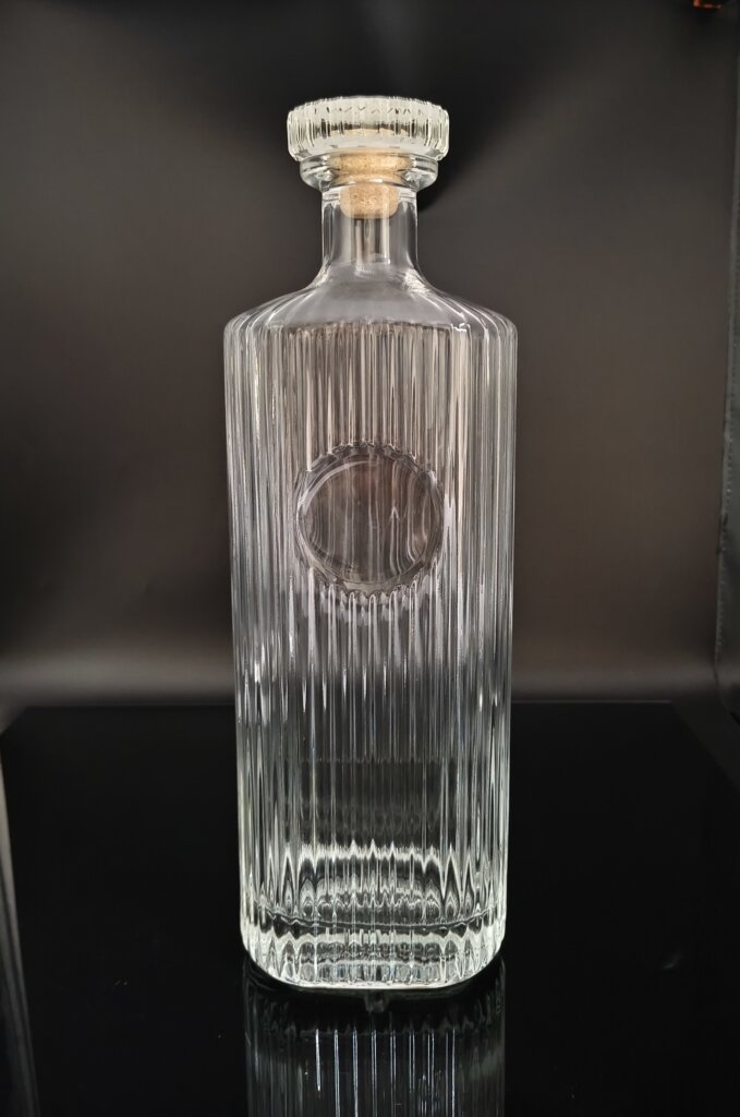 Handcrafted 3000ml crystal white glass spirit bottle with vertical fluted texture and cork stopper for premium liquor packaging.